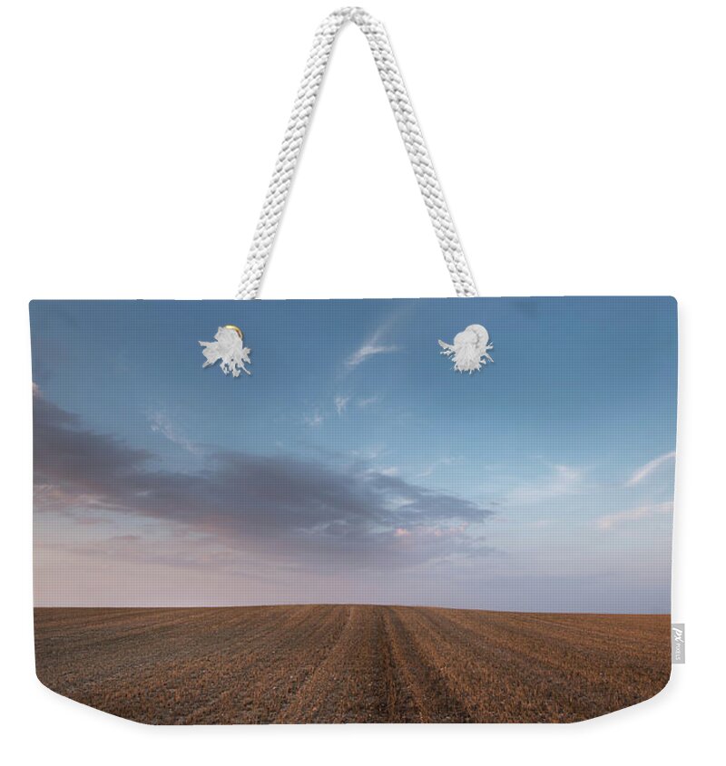 Countryside Weekender Tote Bag featuring the photograph Agricultural meadow field and cloudy sky during sunset. #1 by Michalakis Ppalis