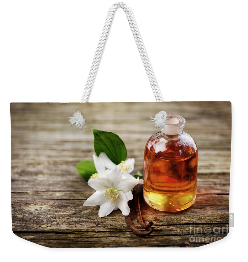 Essential Weekender Tote Bag featuring the photograph Essential Oil with Jasmine Flower and vanilla #1 by Jelena Jovanovic