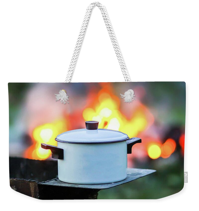 Barbecue Weekender Tote Bag featuring the photograph Meat on the grill and white pan on the brazier on bonfire background #1 by Olga Strogonova