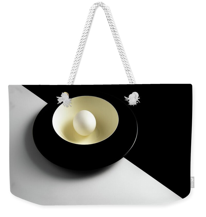 Still-life Weekender Tote Bag featuring the photograph Single fresh white egg on a yellow bowl by Michalakis Ppalis