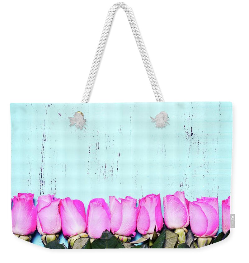 Anniversary Weekender Tote Bag featuring the photograph Vintage aqua blue wood background with pink rose buds. #1 by Milleflore Images