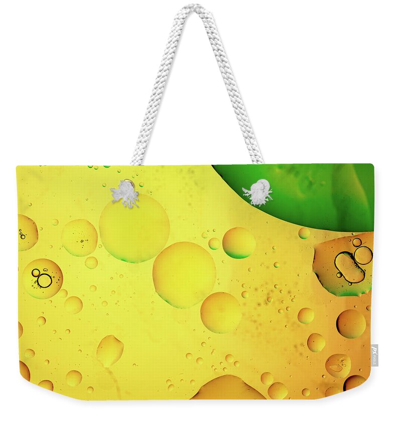 Fluid Weekender Tote Bag featuring the photograph Abstract, image of oil, water and soap with colourful background by Michalakis Ppalis