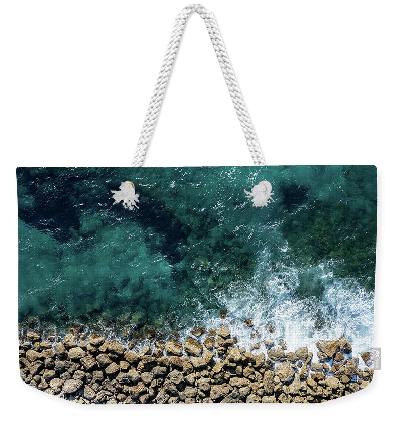 Seascape Weekender Tote Bag featuring the photograph Aerial view from flying drone of crystal blue ocean water and sea wall. by Michalakis Ppalis