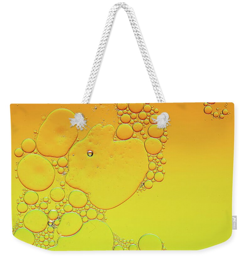 Connection Weekender Tote Bag featuring the photograph Bright abstract, yellow background with flying bubbles by Michalakis Ppalis