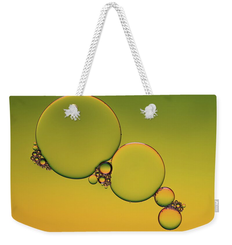 Connection Weekender Tote Bag featuring the photograph Bright abstract, yellow background with flying bubbles by Michalakis Ppalis