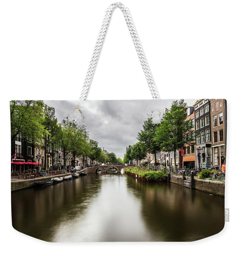 Canal Weekender Tote Bag featuring the photograph Water canal in Amsterdam #3 by Fabiano Di Paolo