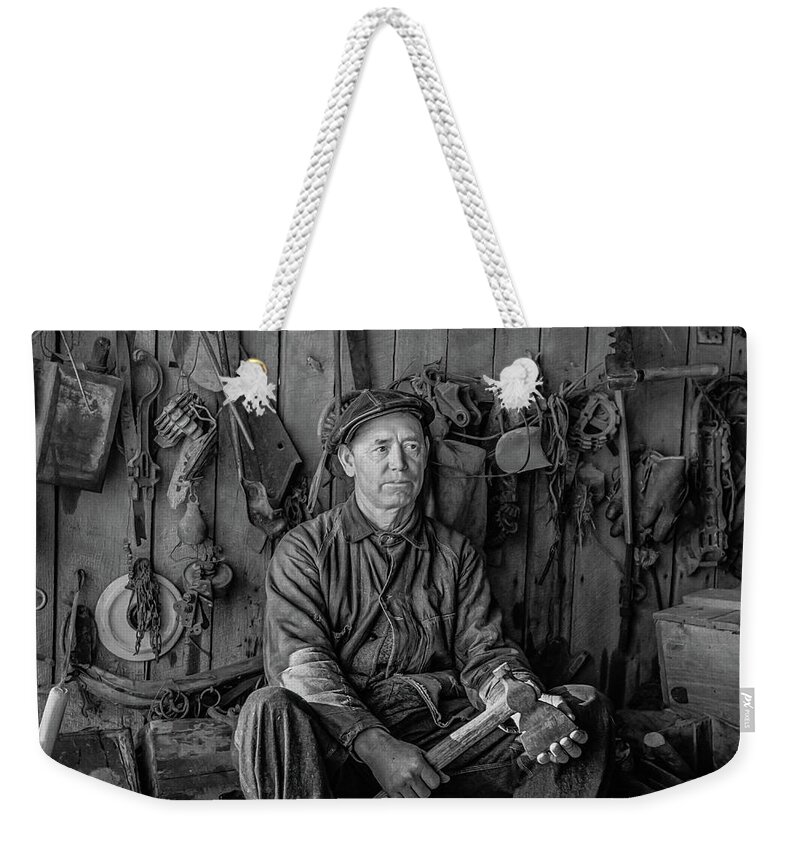 1937 Weekender Tote Bag featuring the photograph A farmer in his toolhouse by David Letts