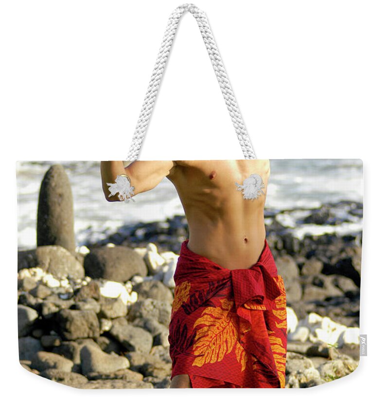 Beach Weekender Tote Bag featuring the photograph A masculine male hula dancer exhibits his manly hula style.	 by Gunther Allen