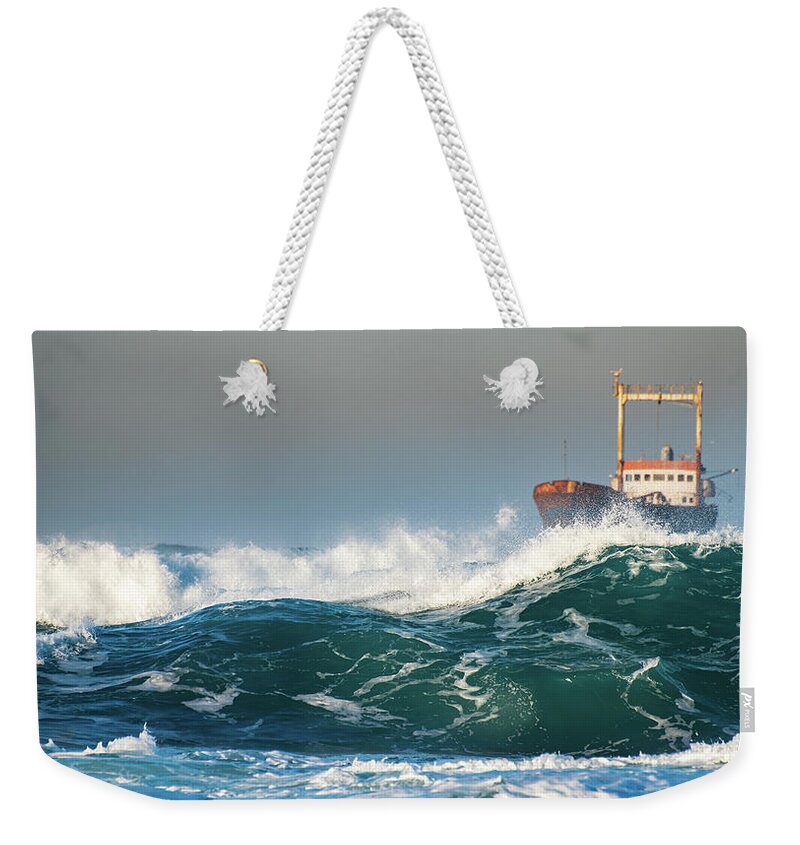 Shipwreck Weekender Tote Bag featuring the photograph Abandoned ship in the stormy ocean by Michalakis Ppalis