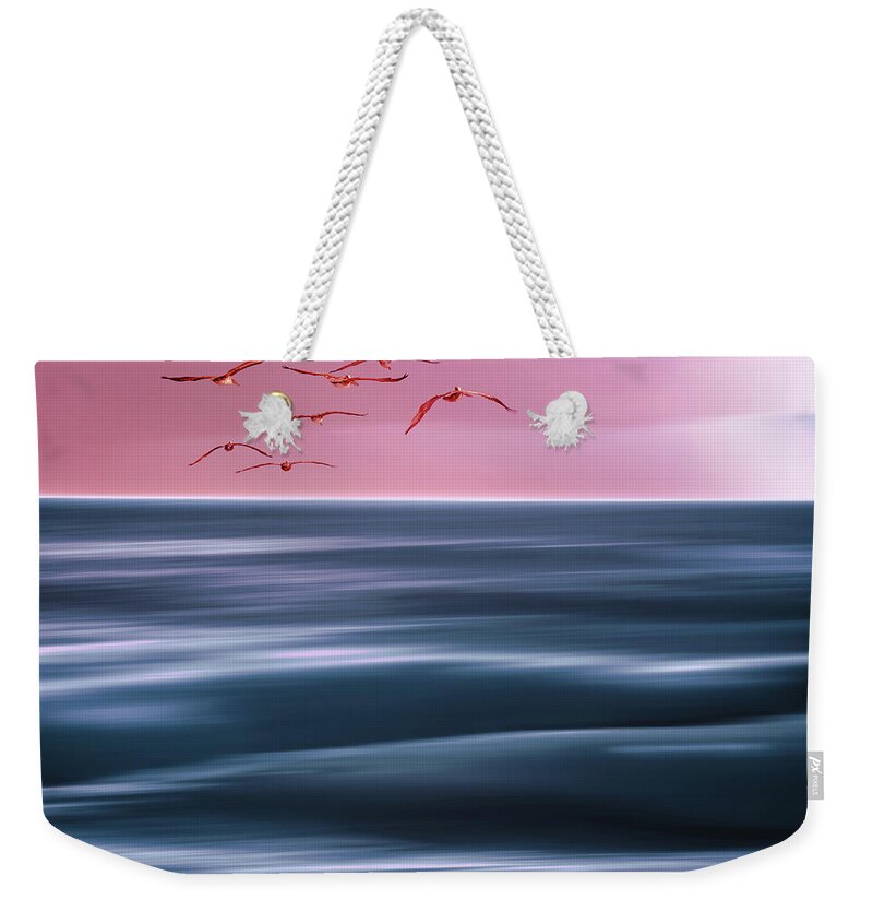 Summer Weekender Tote Bag featuring the photograph Abstract seascape. Pink sunset over the sea, and flock of flying by Hanna Tor