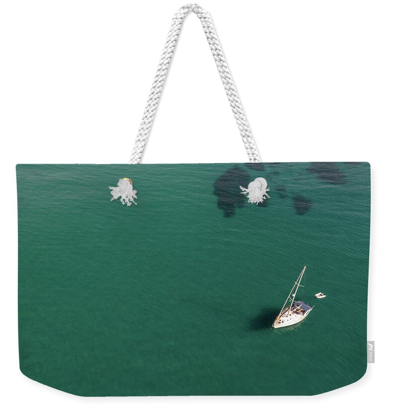 Anchored Weekender Tote Bag featuring the photograph Aerial view of a luxury yacht anchored in the surface of the sea. Cyprus vacations by Michalakis Ppalis