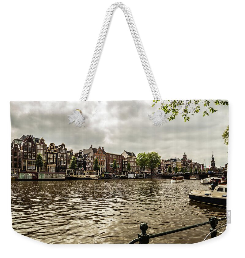 Amstel Weekender Tote Bag featuring the photograph Amsterdam cityscape with Amstel river by Fabiano Di Paolo