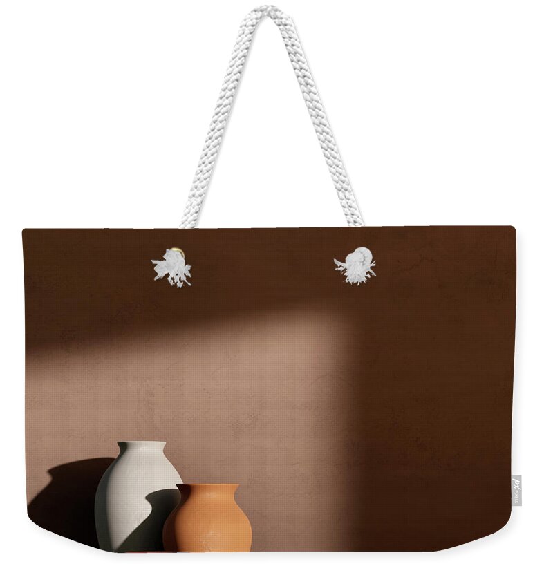 Architecture Weekender Tote Bag featuring the photograph Architecture interior with clay pots on concrete wall by Jelena Jovanovic