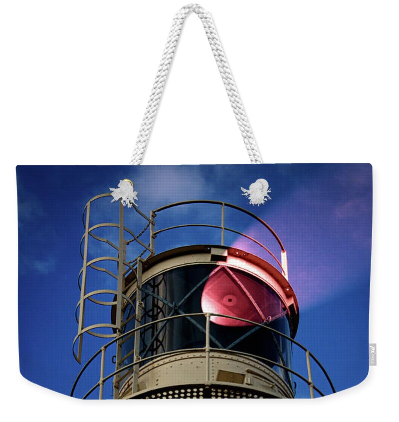 Lighthouse Weekender Tote Bag featuring the photograph Beam of light from a lighthouse. by Bernhard Schaffer