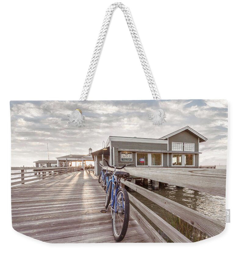 Clouds Weekender Tote Bag featuring the photograph Blue Bicycles on the Jekyll Island Beach Boardwalk Pier by Debra and Dave Vanderlaan