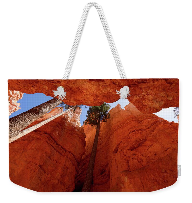 America Weekender Tote Bag featuring the photograph Blue sky piercing between two orange cliffs by Jean-Luc Farges