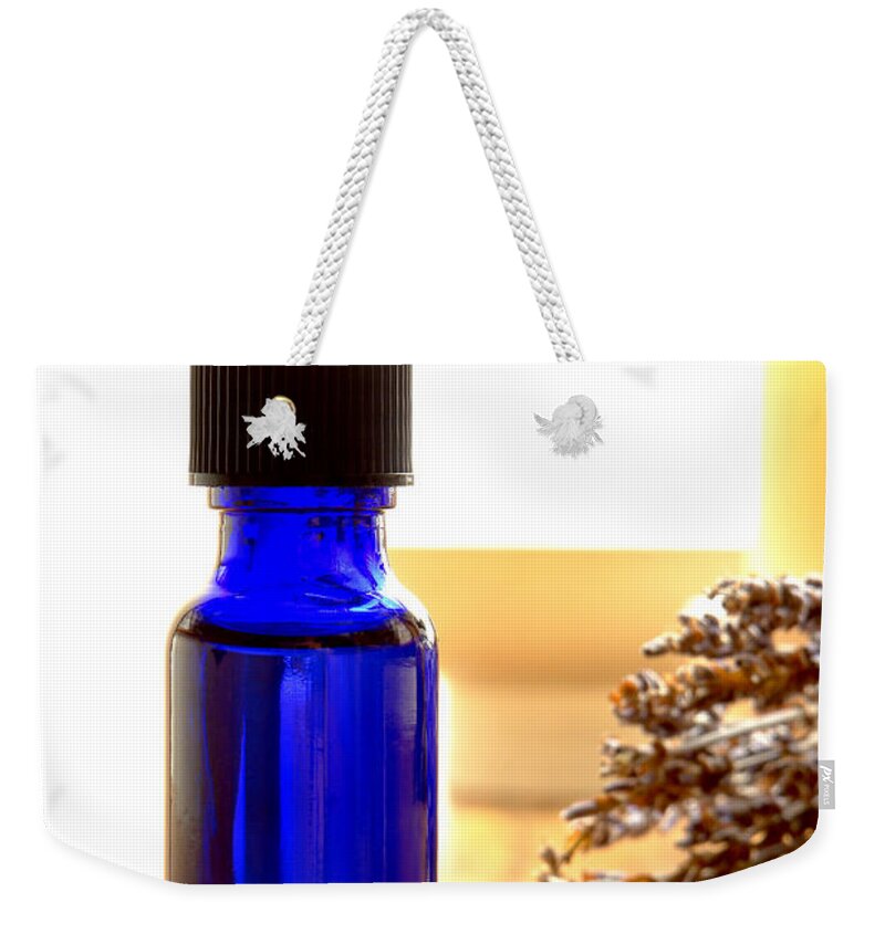 Blue Weekender Tote Bag featuring the photograph Bottle of Aromatherapy Lavender Extract Essential Oil by Olivier Le Queinec