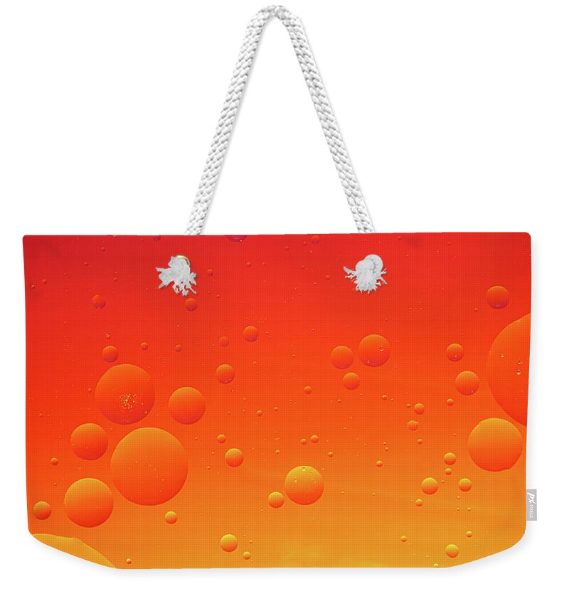 Abstract Weekender Tote Bag featuring the photograph Bright abstract, red background with flying bubbles by Michalakis Ppalis