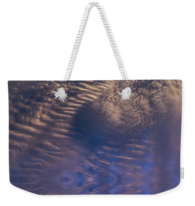 Clouds Weekender Tote Bag featuring the digital art Bronze colored clouds in the dark blue sky by Adriana Mueller