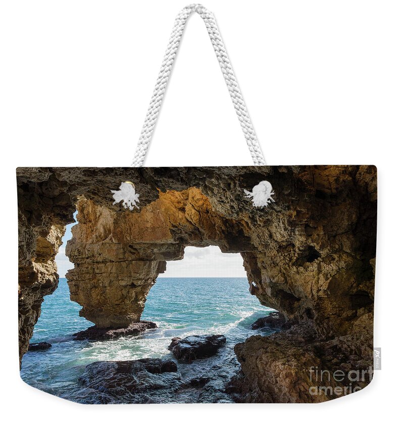 Coast Weekender Tote Bag featuring the photograph Cave on the Mediterranean coast, Cova del Arcs by Adriana Mueller