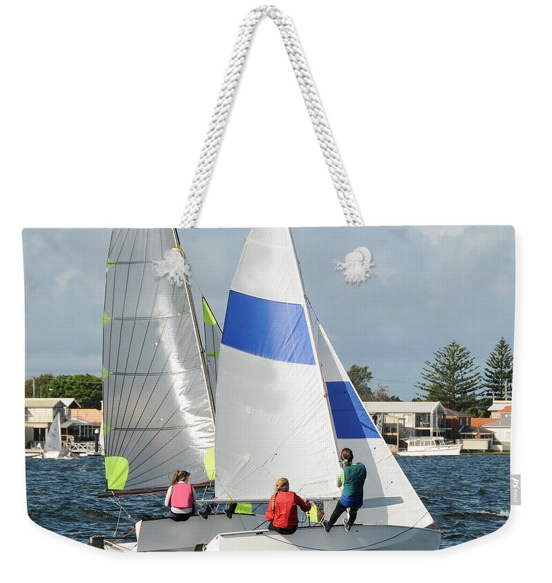 Csne63 Weekender Tote Bag featuring the photograph Children close racing small sailboats on a coastal lake. by Geoff Childs
