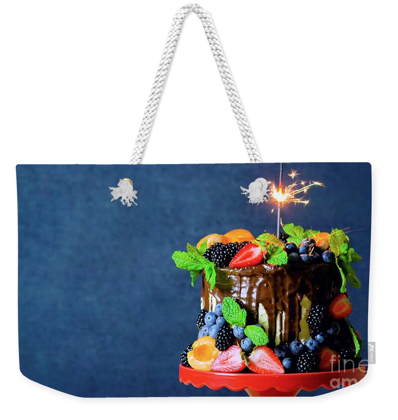 Birthday Weekender Tote Bag featuring the photograph Chocolate drip cake decorated with fresh fruit and berries with copy space. by Milleflore Images