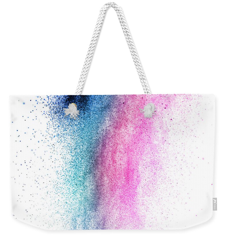 Dust Weekender Tote Bag featuring the photograph Color powder splash isolated on white background. Blue and purpl by Jelena Jovanovic
