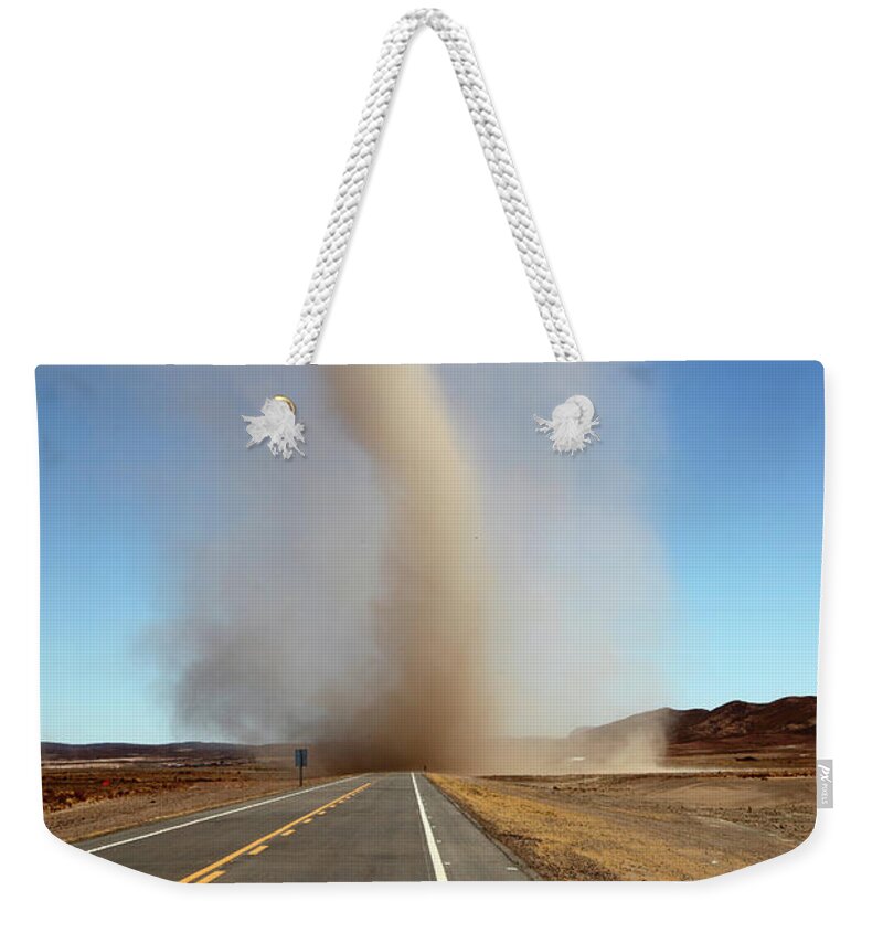 Dust Devil Weekender Tote Bag featuring the photograph Dust devil crossing the road Bolivia by James Brunker