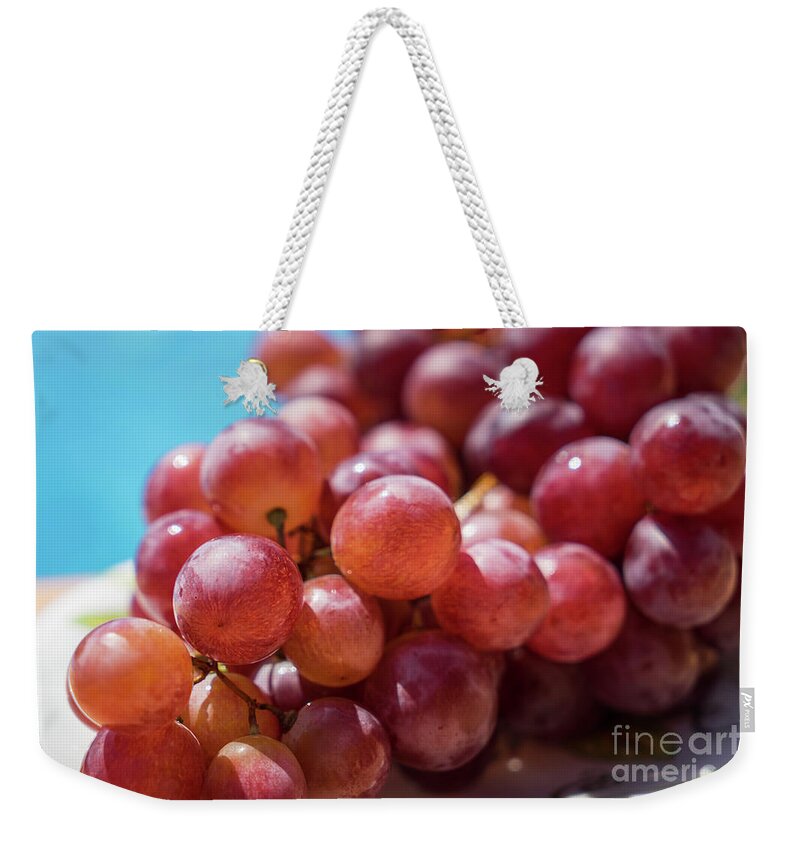Red Weekender Tote Bag featuring the photograph Fresh Red Grapes In The Summer Sun by Adriana Mueller