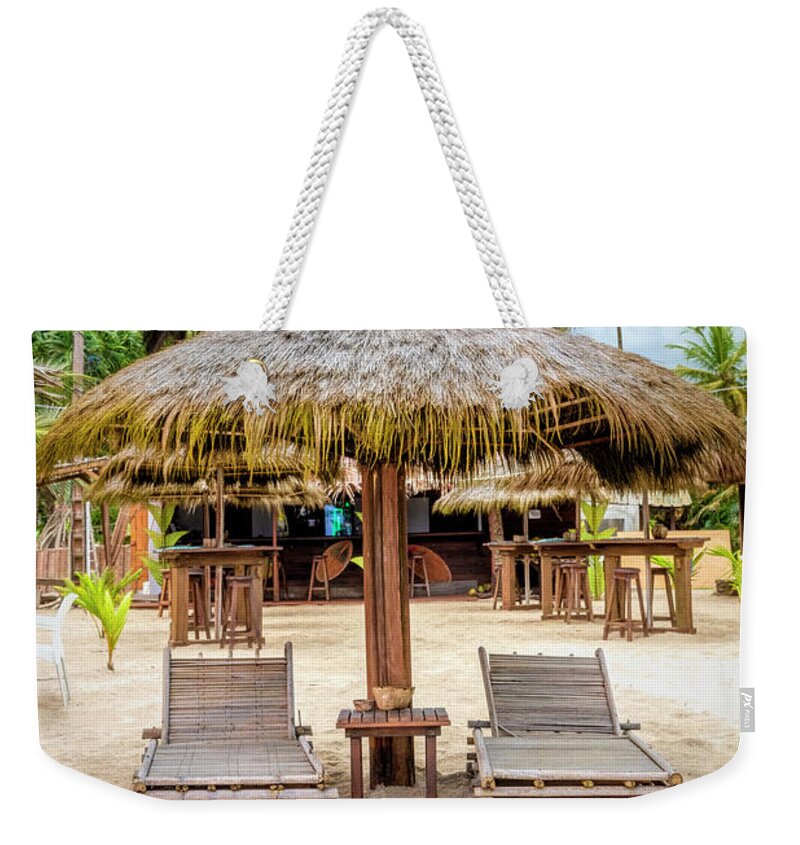 African Weekender Tote Bag featuring the photograph Grass Umbrellas on the Beach by Debra and Dave Vanderlaan