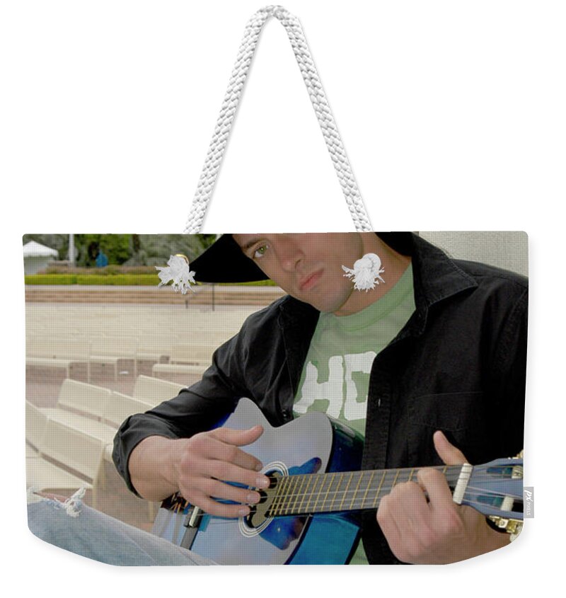 Young Weekender Tote Bag featuring the photograph Handsome young cowboy playing the guitar by Gunther Allen