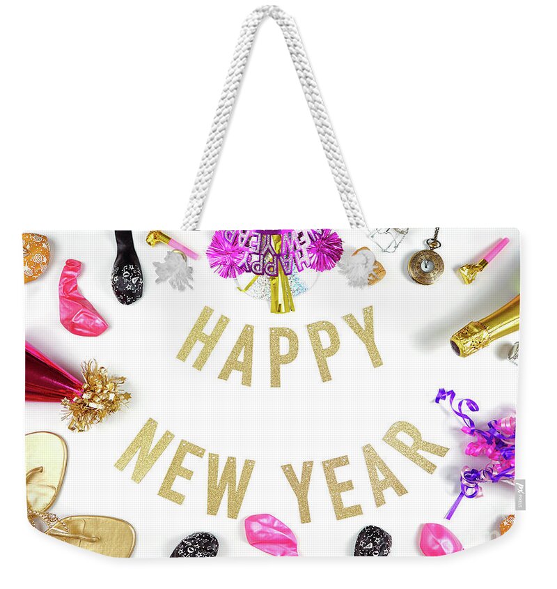 2020 Weekender Tote Bag featuring the photograph Happy New Year's Eve banner with champagne and pink and gold party decorations. by Milleflore Images