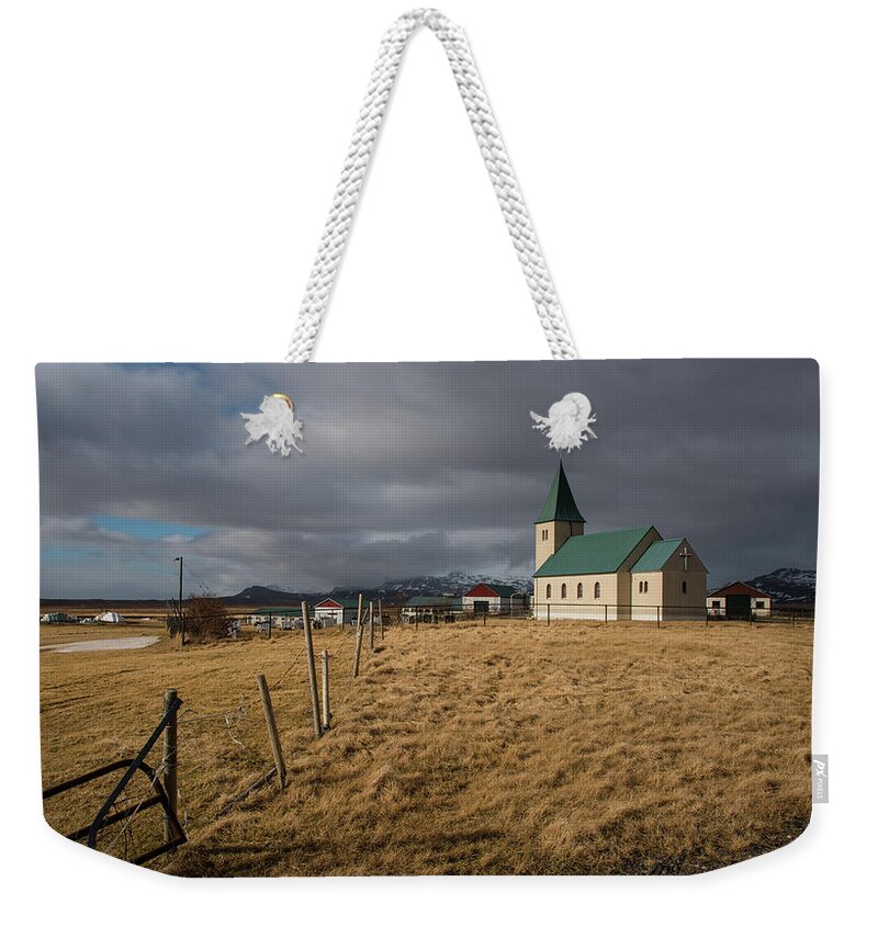 Icelandic Weekender Tote Bag featuring the photograph Icelandinc landscape with traditional church in Iceland by Michalakis Ppalis