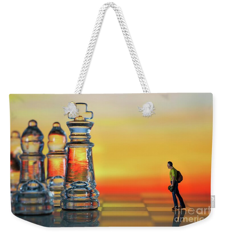 Rule Weekender Tote Bag featuring the photograph Miniature figure people as businessman standing face to face with King chess piece on chessboard. Sunset background. Macro by Pablo Avanzini