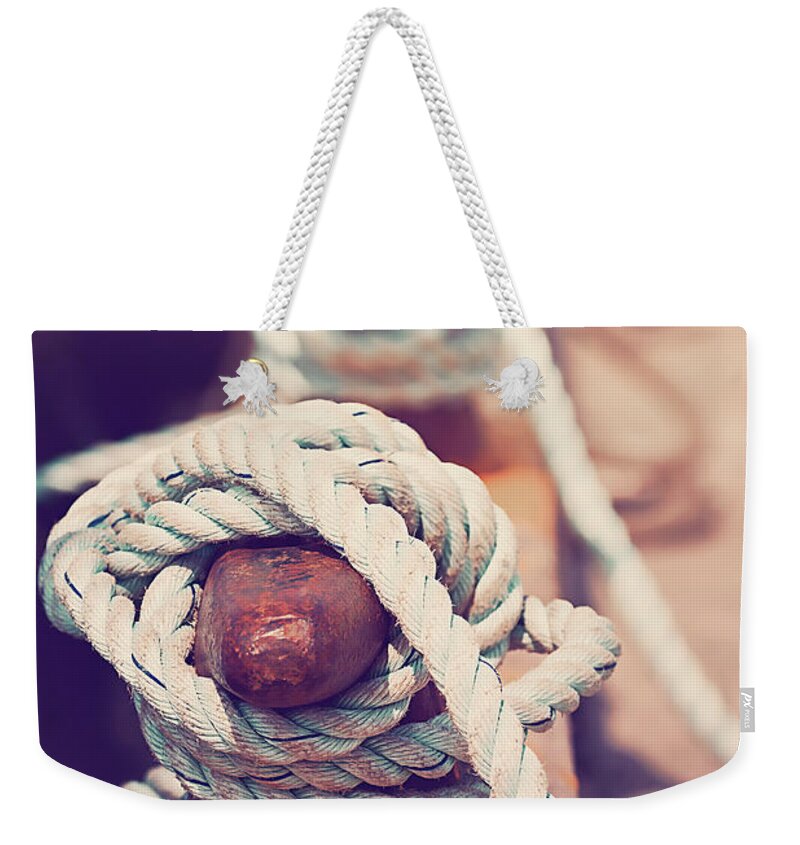 Sea Weekender Tote Bag featuring the photograph Quayside cleats and tied ropes with boats moored in the backgrou by Jane Rix