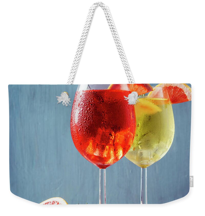 Aperol Weekender Tote Bag featuring the photograph Red and white aperol spritz garnish in wine glasses by Jelena Jovanovic