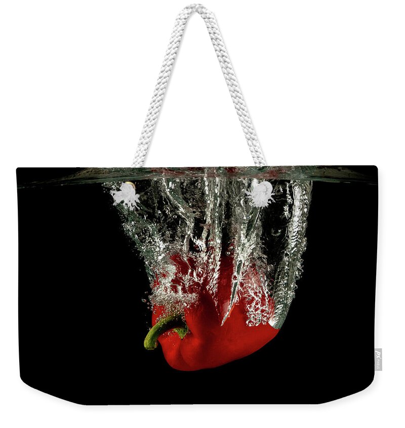 Pepper Weekender Tote Bag featuring the photograph Red bell pepper dropped and slashing on water by Michalakis Ppalis