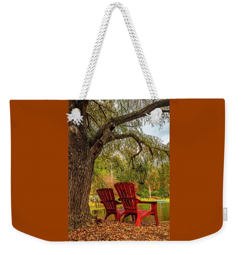 Carolina Weekender Tote Bag featuring the photograph Red Chairs at the Pond by Debra and Dave Vanderlaan
