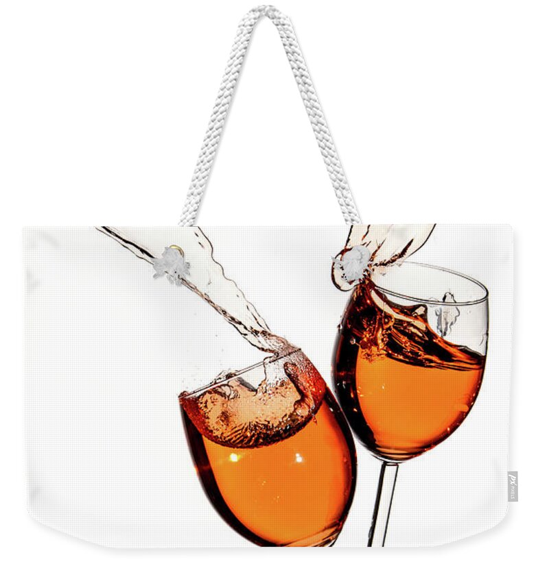 Alcohol Weekender Tote Bag featuring the photograph Red wine in glasses with splashes on a white background isolated by Michalakis Ppalis
