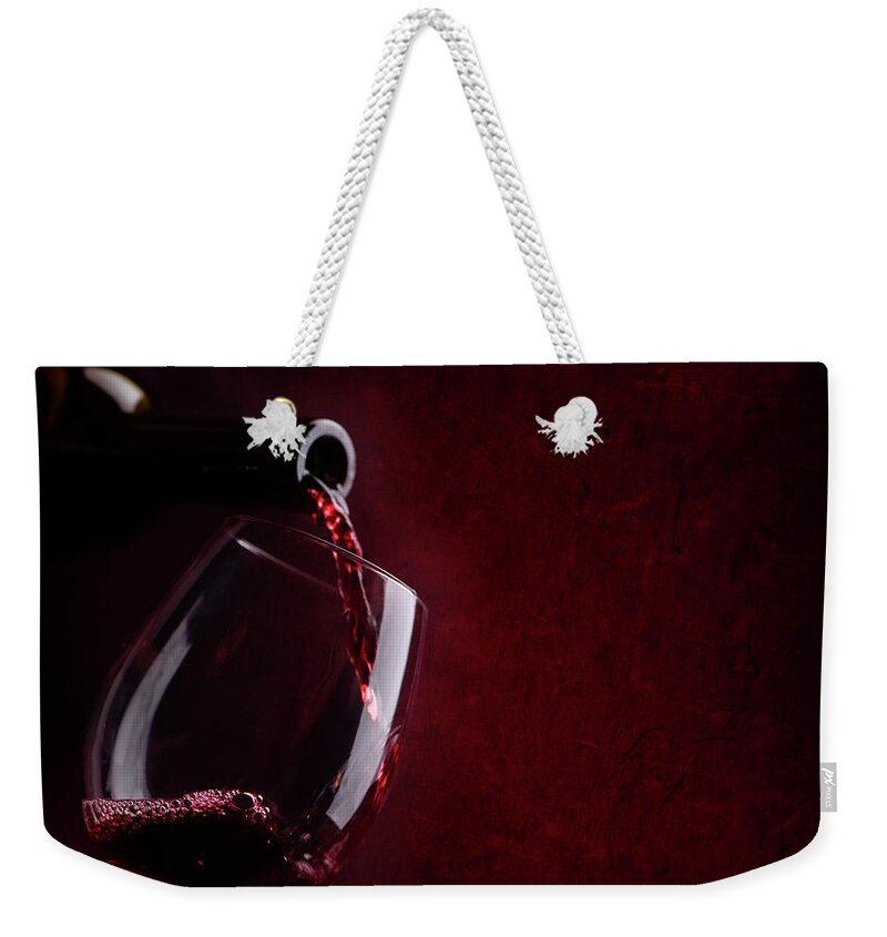 Wine Weekender Tote Bag featuring the photograph Red wine pouring in wineglass by Jelena Jovanovic