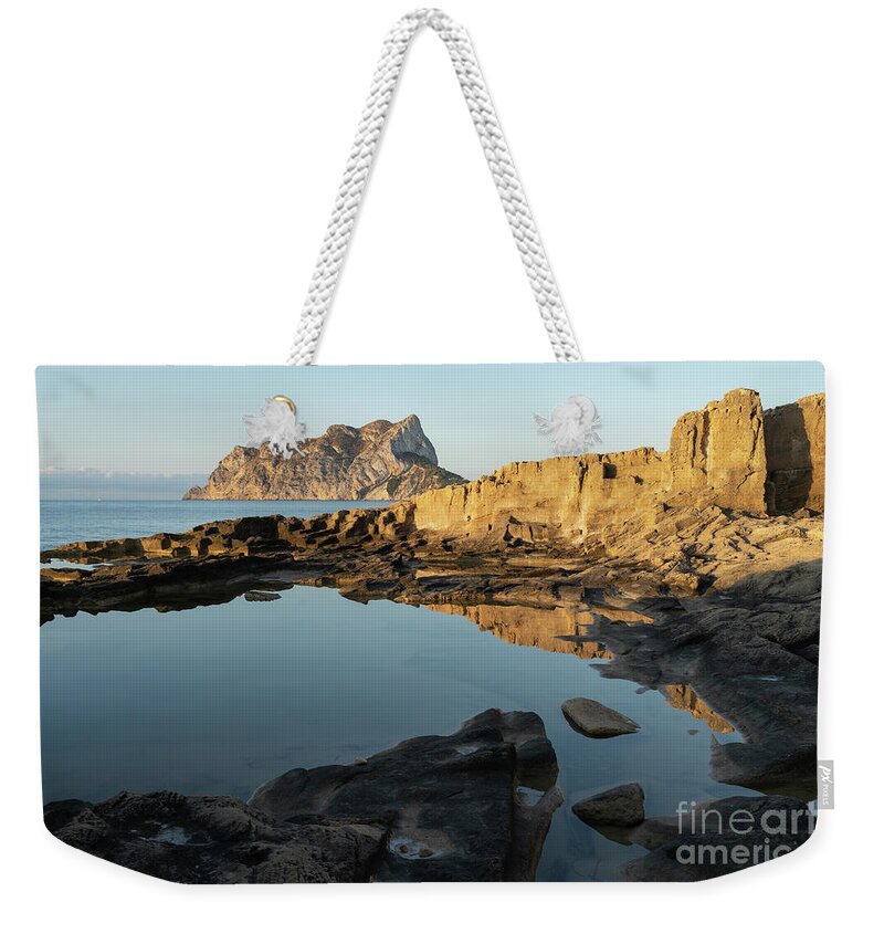 Mediterranean Weekender Tote Bag featuring the photograph Reflection of rocks in the calm Mediterranean Sea at sunrise 1 by Adriana Mueller