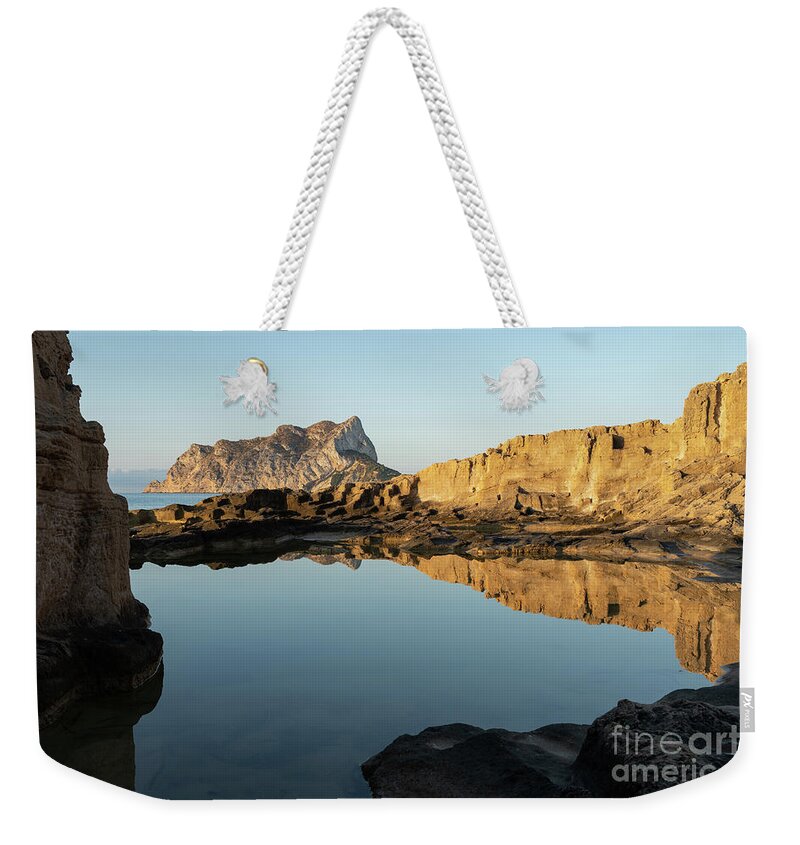 Mediterranean Weekender Tote Bag featuring the photograph Reflection of rocks in the calm Mediterranean Sea at sunrise 3 by Adriana Mueller