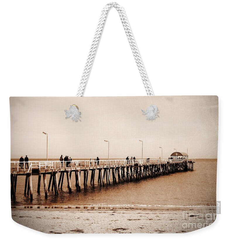 Jetty Weekender Tote Bag featuring the photograph Retro grunge vintage style sepia people on jetty pier boardwalk. by Milleflore Images