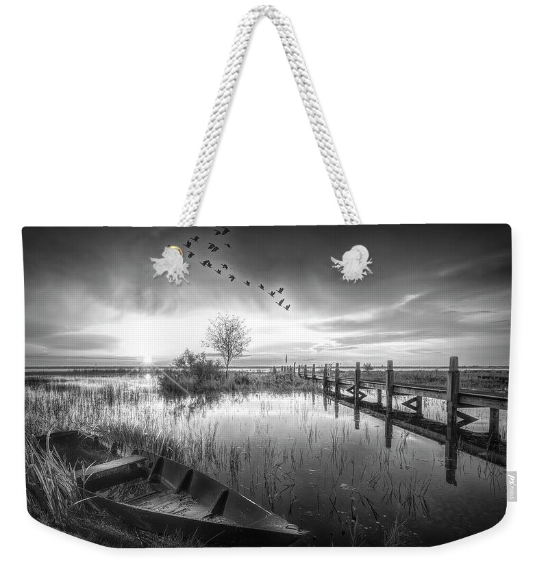 Birds Weekender Tote Bag featuring the photograph Rowboat in the Marsh at Sunset in Black and White by Debra and Dave Vanderlaan