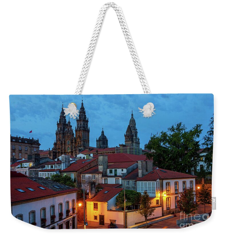 Way Weekender Tote Bag featuring the photograph Santiago de Compostela Cathedral Spectacular View by Night Dusk with Street Lights and Tiled Roofs La Corua Galicia by Pablo Avanzini