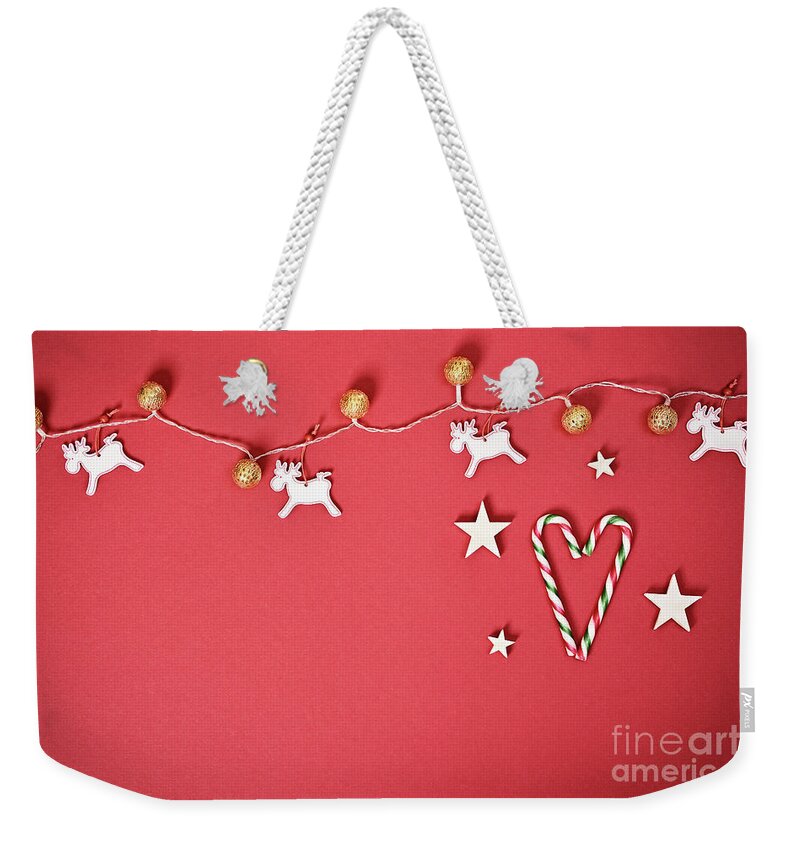 Seasonal Weekender Tote Bag featuring the photograph Seasonal greeting card concept with Christmas lights and candy cane heart by Mendelex Photography