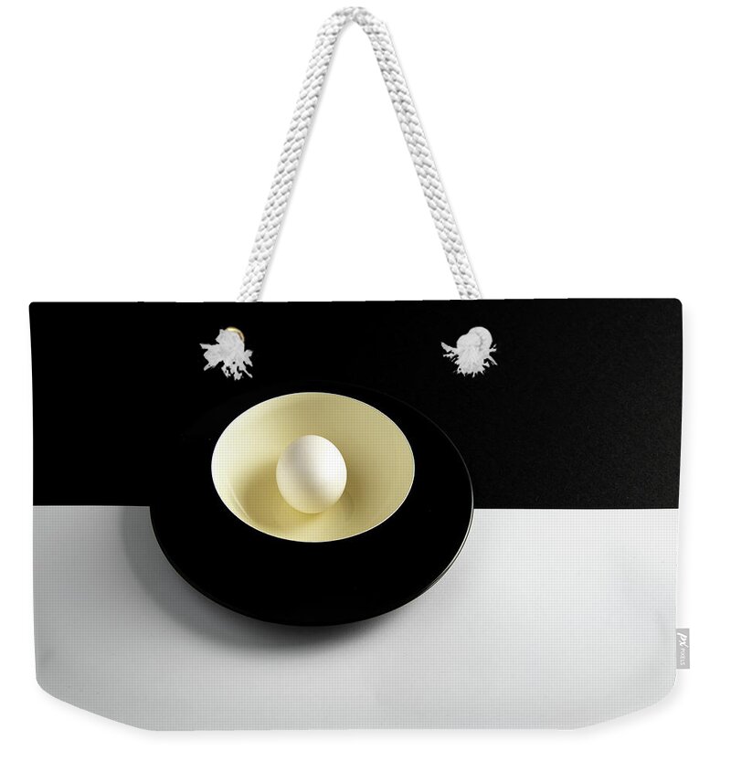 Still-life Weekender Tote Bag featuring the photograph Single fresh white egg on a yellow bowl by Michalakis Ppalis