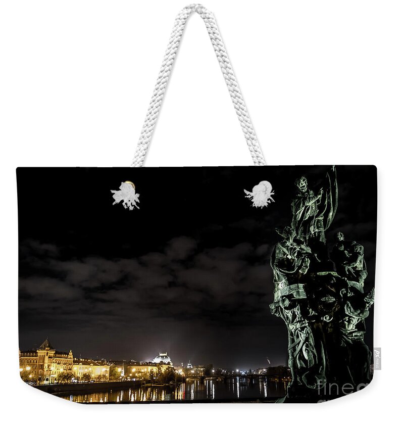 Ancient Weekender Tote Bag featuring the photograph Statue On Charles Bridge And Illuminated Buildings In Prague In The Czech Republic by Andreas Berthold
