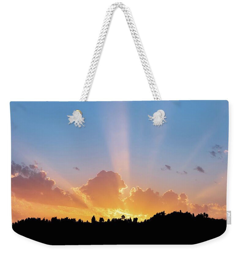 Sunbeam Weekender Tote Bag featuring the photograph Sunbeams Shining Over Tree Silhouettes by Alexios Ntounas