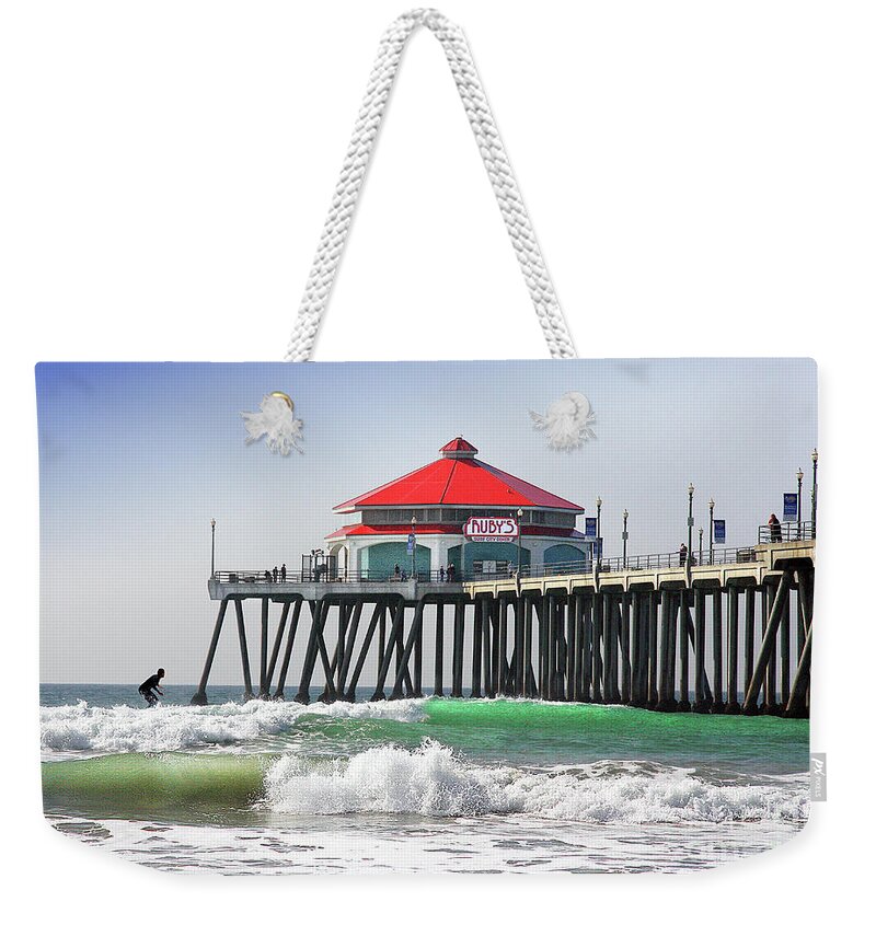 Surfing At Ruby�s Cafe On The Huntington Beach California City Pier Ocean Surfing Fine Art Photography Print Weekender Tote Bag featuring the photograph Surfing At Rubys Cafe by Jerry Cowart